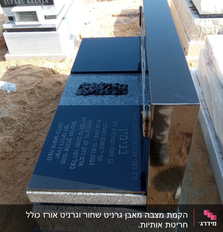 מצבות שחורות עם כיתוב ואבנים קטנות מונחות
